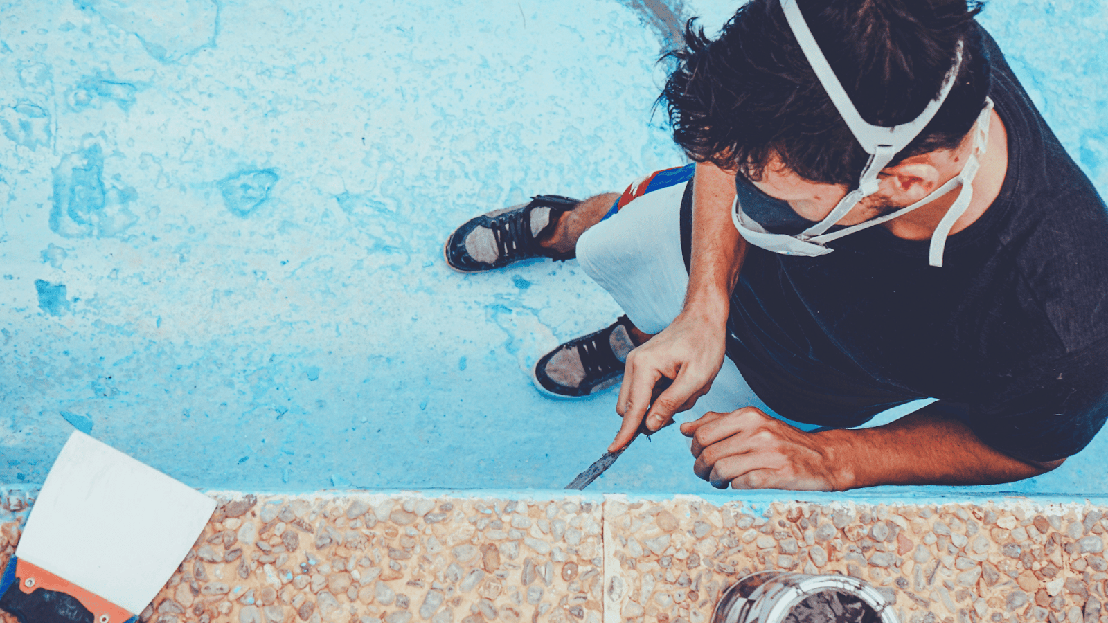 Preparing pool wall recess by cleaning and leveling before underwater window installation