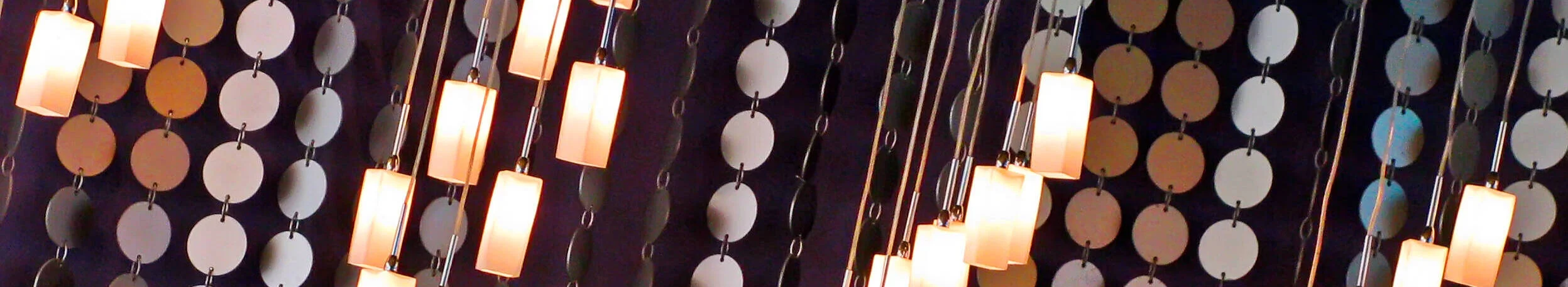 A group of lights hangs from the ceiling, adorned with decorative strips of plastic for added visual appeal.