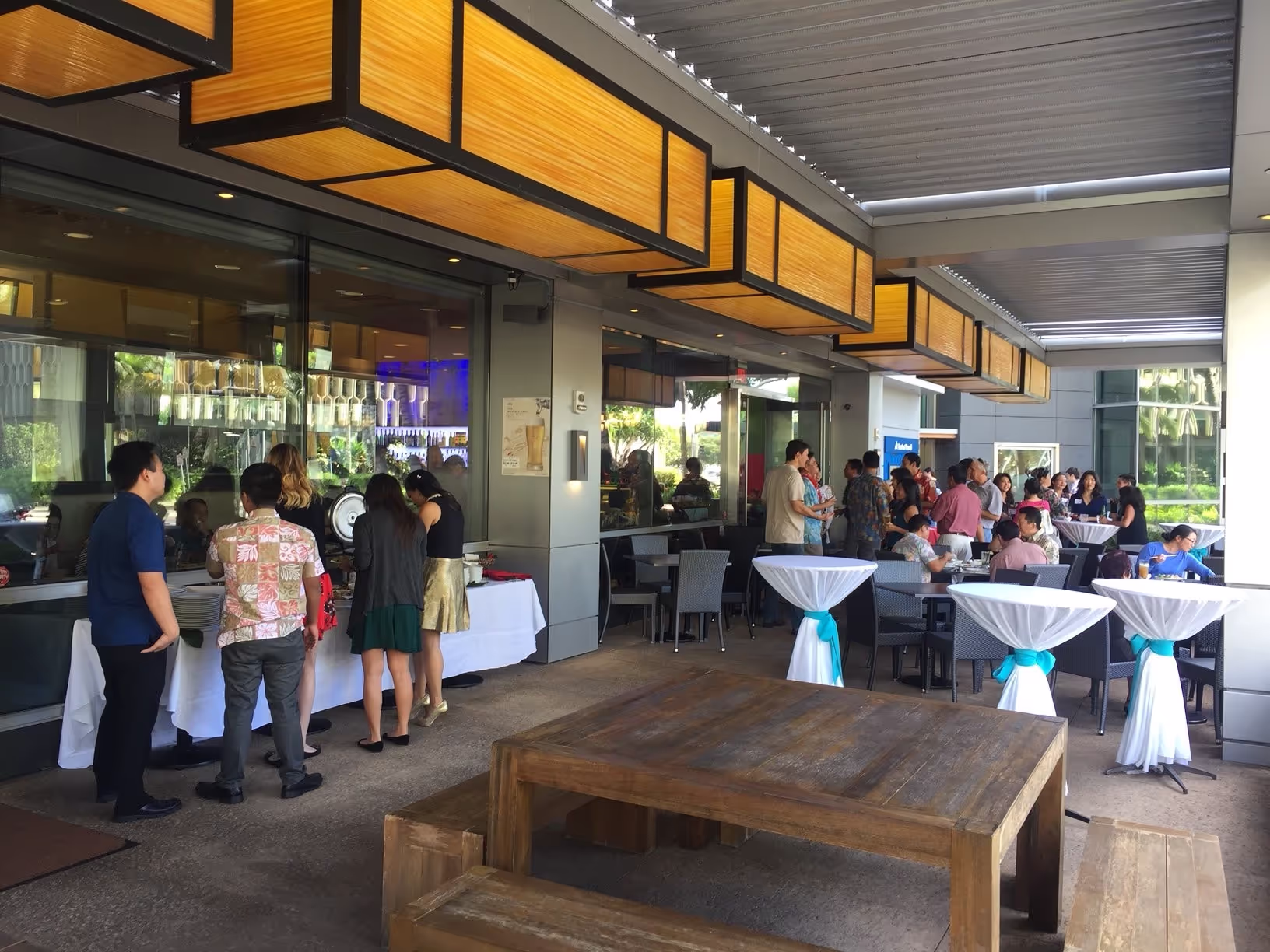A group of people gathered around tables at a restaurant, engaged in conversation during a lively event.