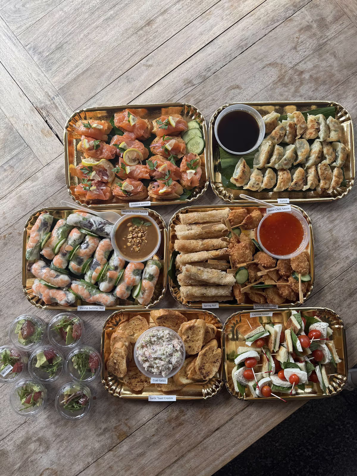 A table displaying multiple trays filled with various types of food, arranged for serving.