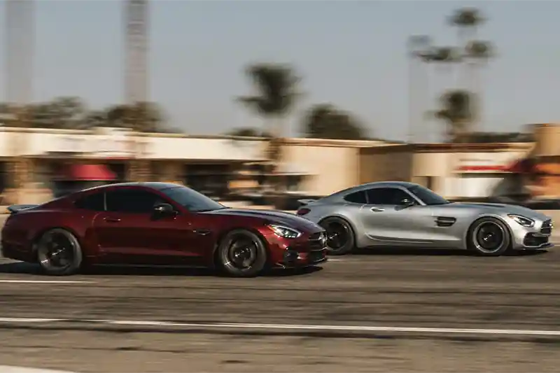 Two sports cars driving fast on a city street, which can lead to reckless driving charges and need a traffic attorney in Fresno