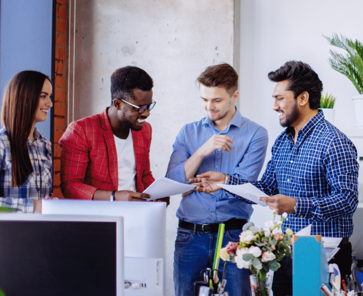 A group of people standing around a desk.