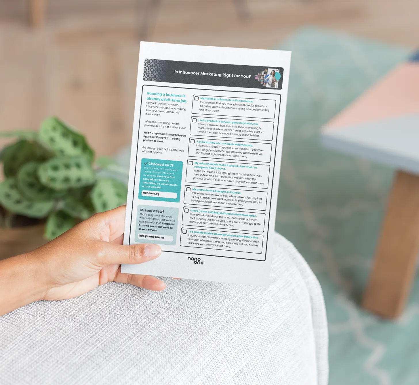 image of a hand holding a flyer on an armchair