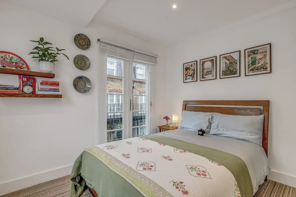 Spacious bedroom with plush bedding and natural light