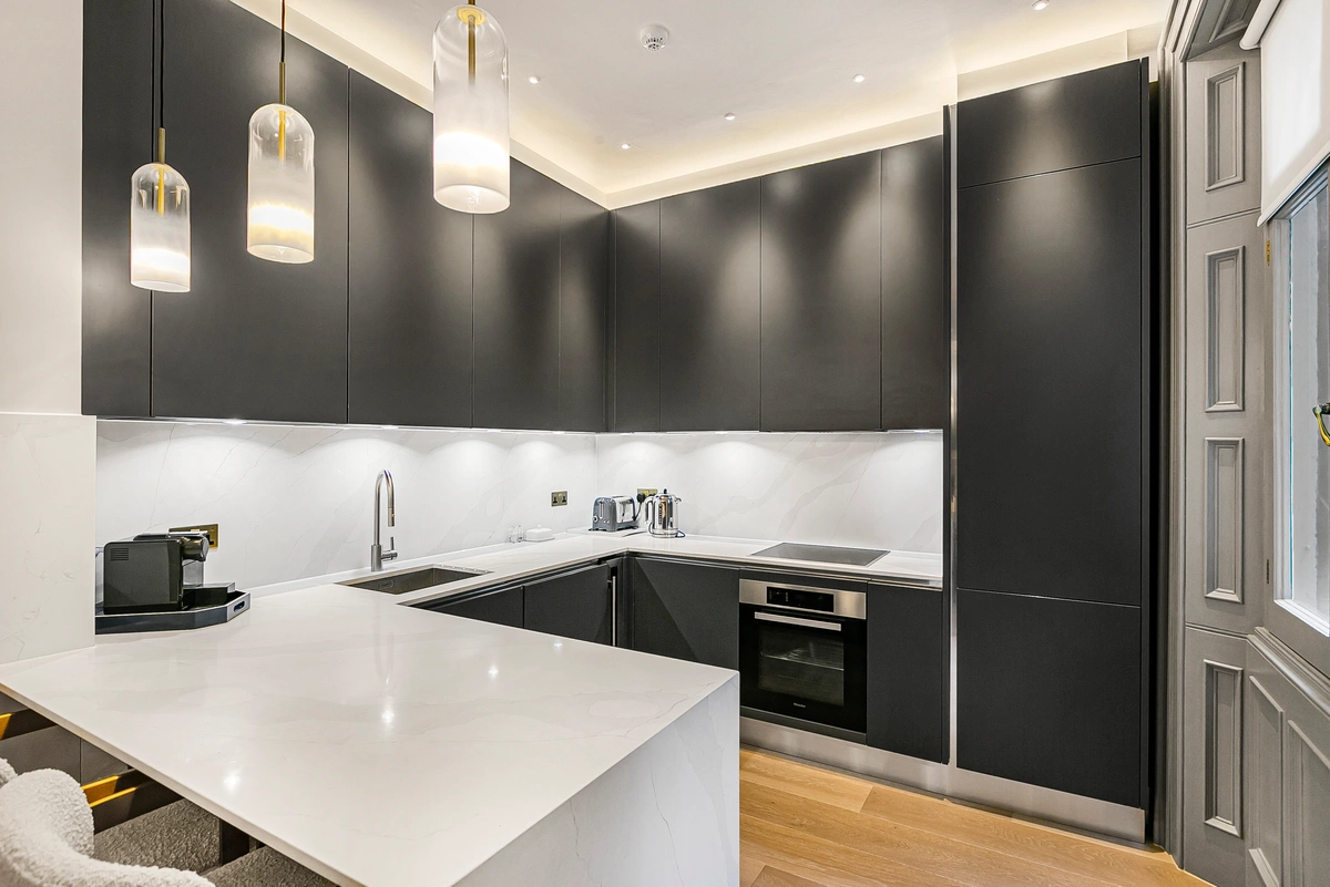 Open kitchen with top-tier appliances and marble backsplash