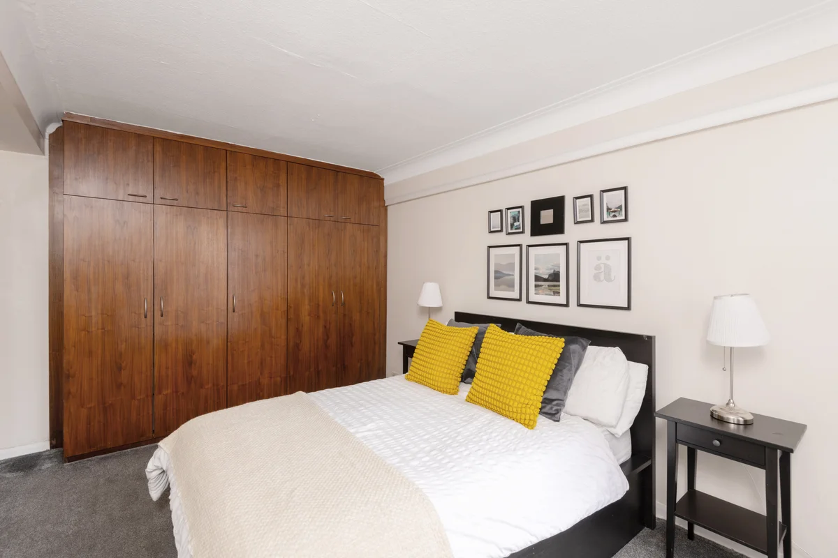 Bright bedroom with a large bed, soft textiles, and minimalist decor