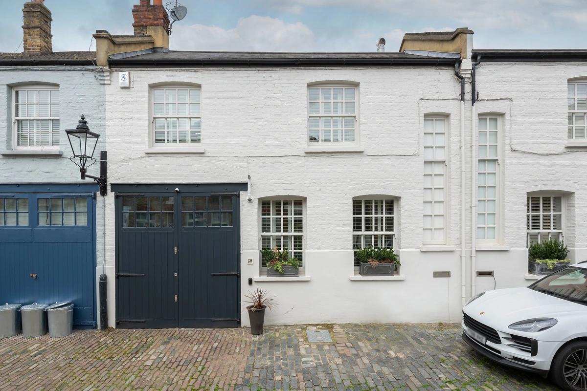 Exterior view of the traditional British mews house on a cobbled street