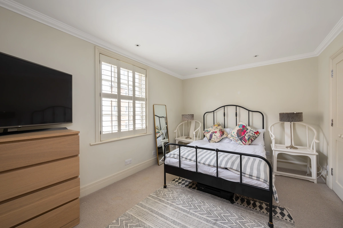 Elegant bedroom with plush linens, soft lighting, and classic British charm