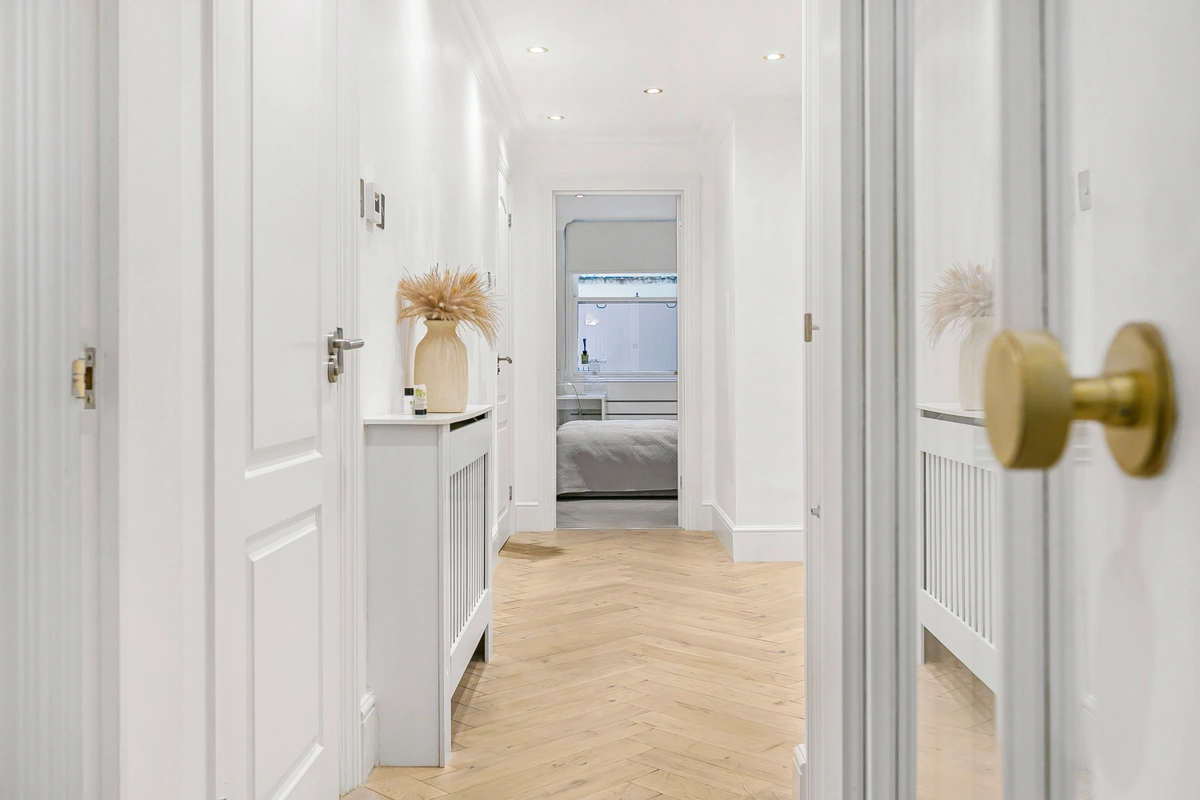 Elegant hallway with polished floors and framed artwork on the walls