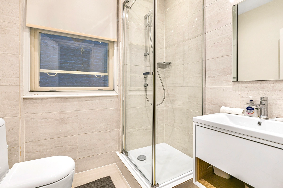 Bathroom with marble surfaces and a spacious walk-in shower
