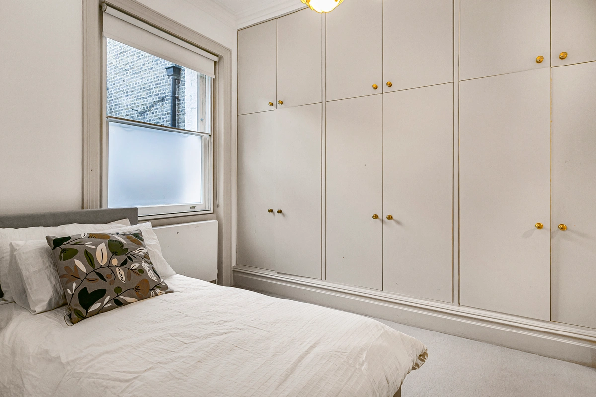 Guest bedroom with large windows and upscale linens