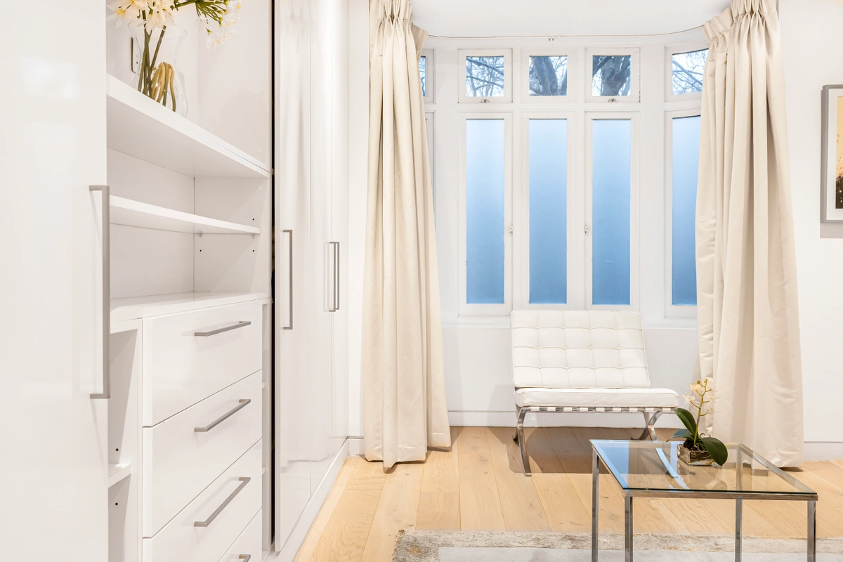 Walk-in dressing area with custom cabinetry and a full-length mirror
