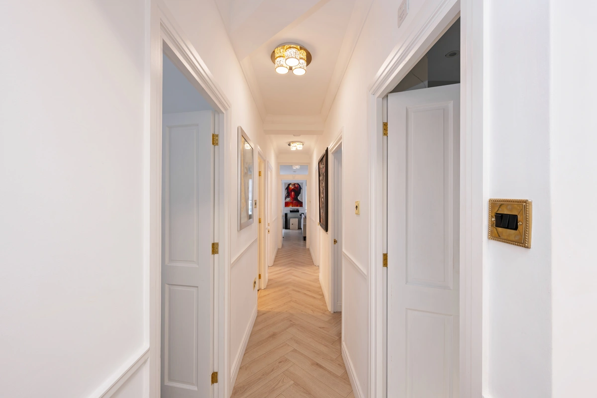 Well-lit corridor connecting rooms with stylish flooring