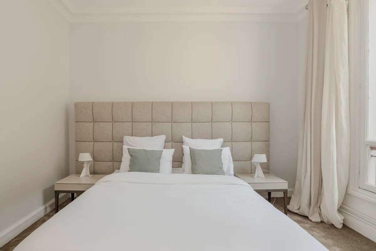 Fifth angle of the inviting bedroom at Casa Cribs with plush bedding and warm lighting.