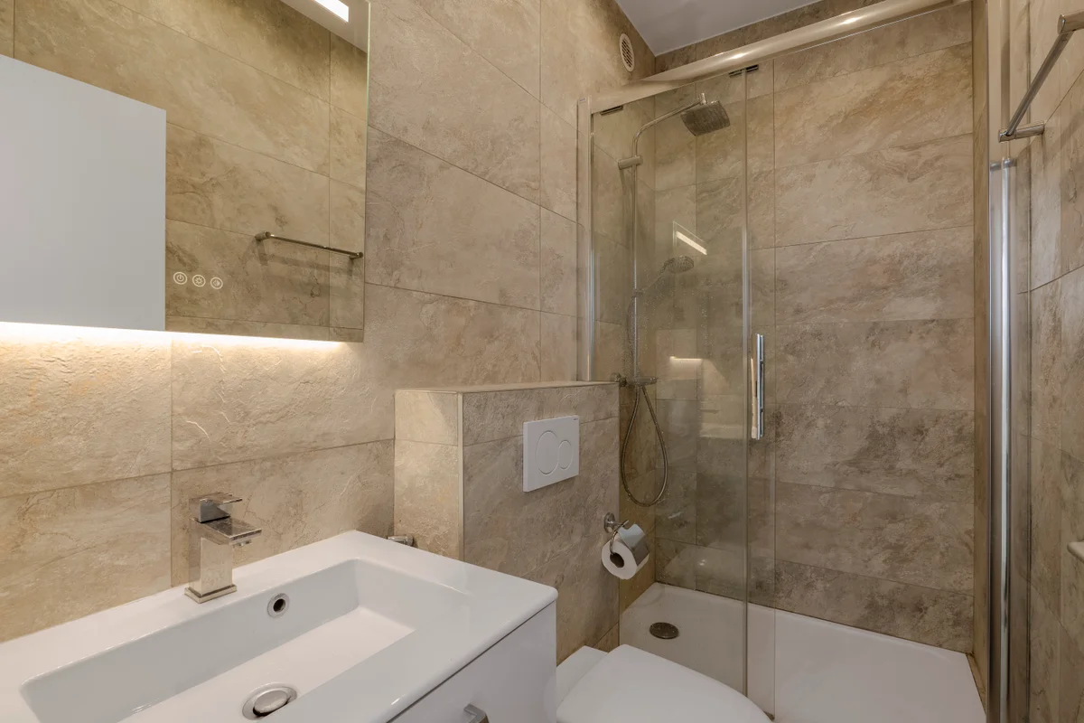 Luxurious marble bathroom at Casa Cribs with a rainfall shower and spa-like ambiance.