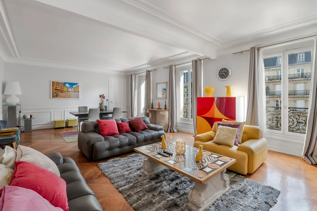Full view of the bright and inviting living area at Casa Cribs with bold artwork and natural light.