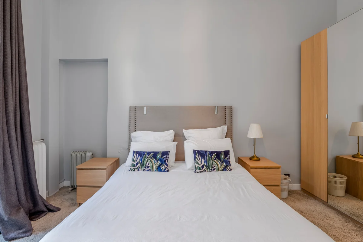 	Second view of the elegant bedroom at Casa Cribs with natural light and refined furnishings.