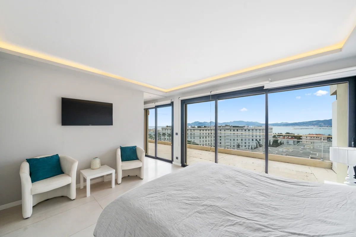 Luxurious bedroom at Casa Cribs featuring a king-sized bed, elegant decor, and breathtaking sea views.