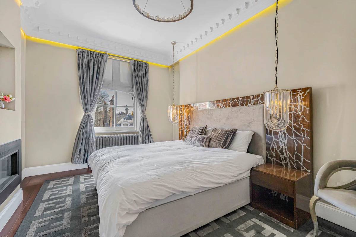 Elegant bedroom at Casa Cribs featuring a plush king-sized bed, refined decor, and natural light.