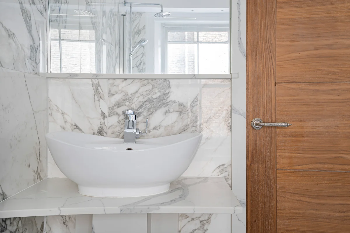 	Luxurious marble-clad bathroom at Casa Cribs with a deep soaking tub and rainfall shower.