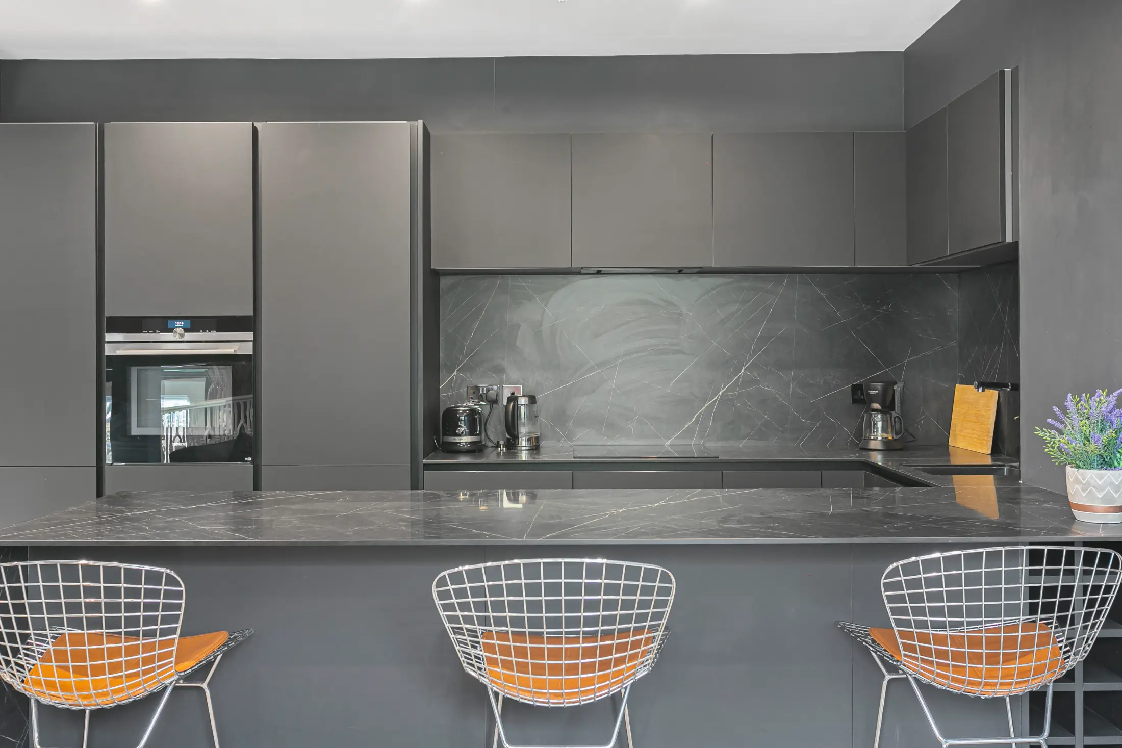 Sleek bar area at Casa Cribs with high chairs adding a contemporary touch to the kitchen.