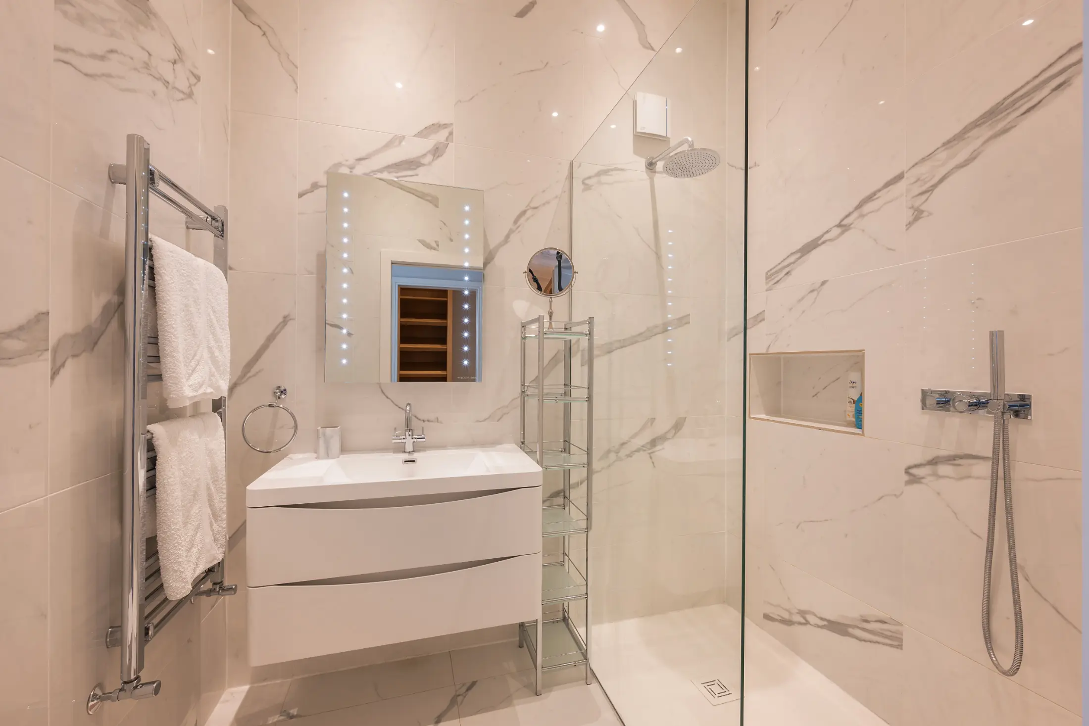Second angle of the luxurious bathroom at Casa Cribs featuring marble details and refined fixtures.