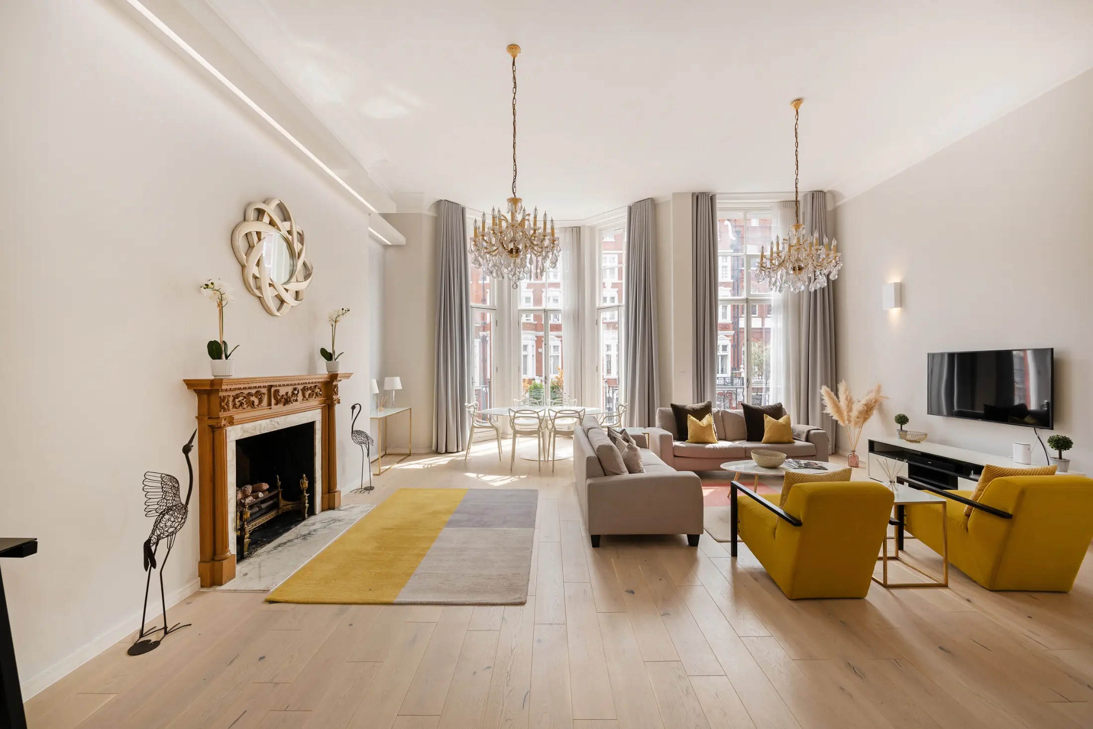 Fifth perspective of the elegant living room at Casa Cribs with statement lighting and luxurious decor.