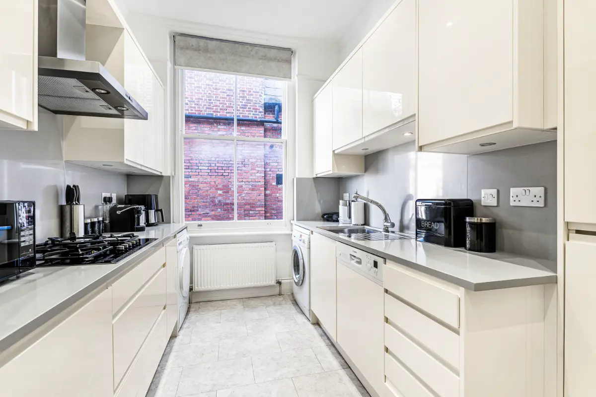 Bright and modern kitchen at Casa Cribs featuring marble countertops and sleek design.