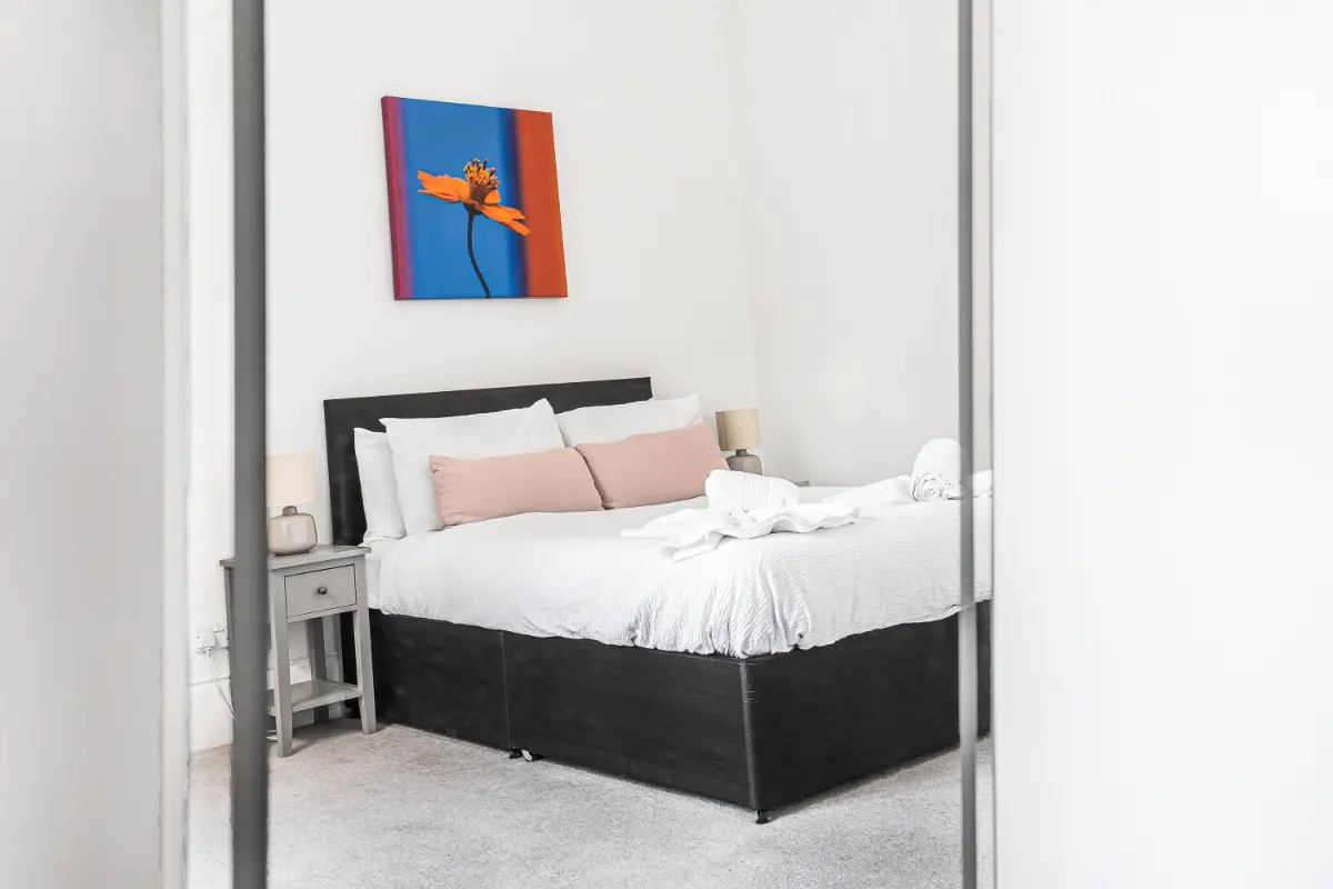 Second bedroom at Casa Cribs with a serene color palette and cozy linens.