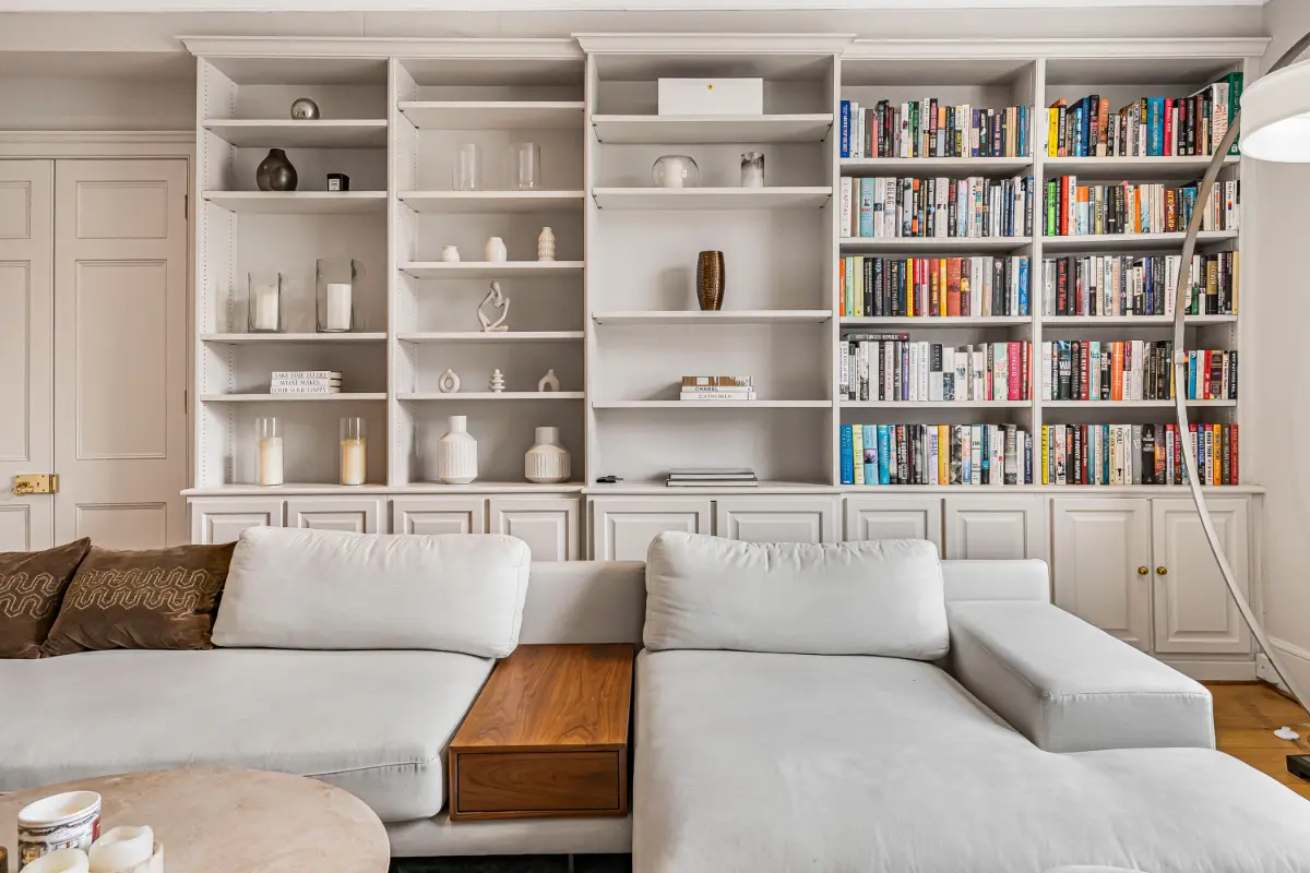 Living area at Casa Cribs with a cozy sofa and a built-in library.