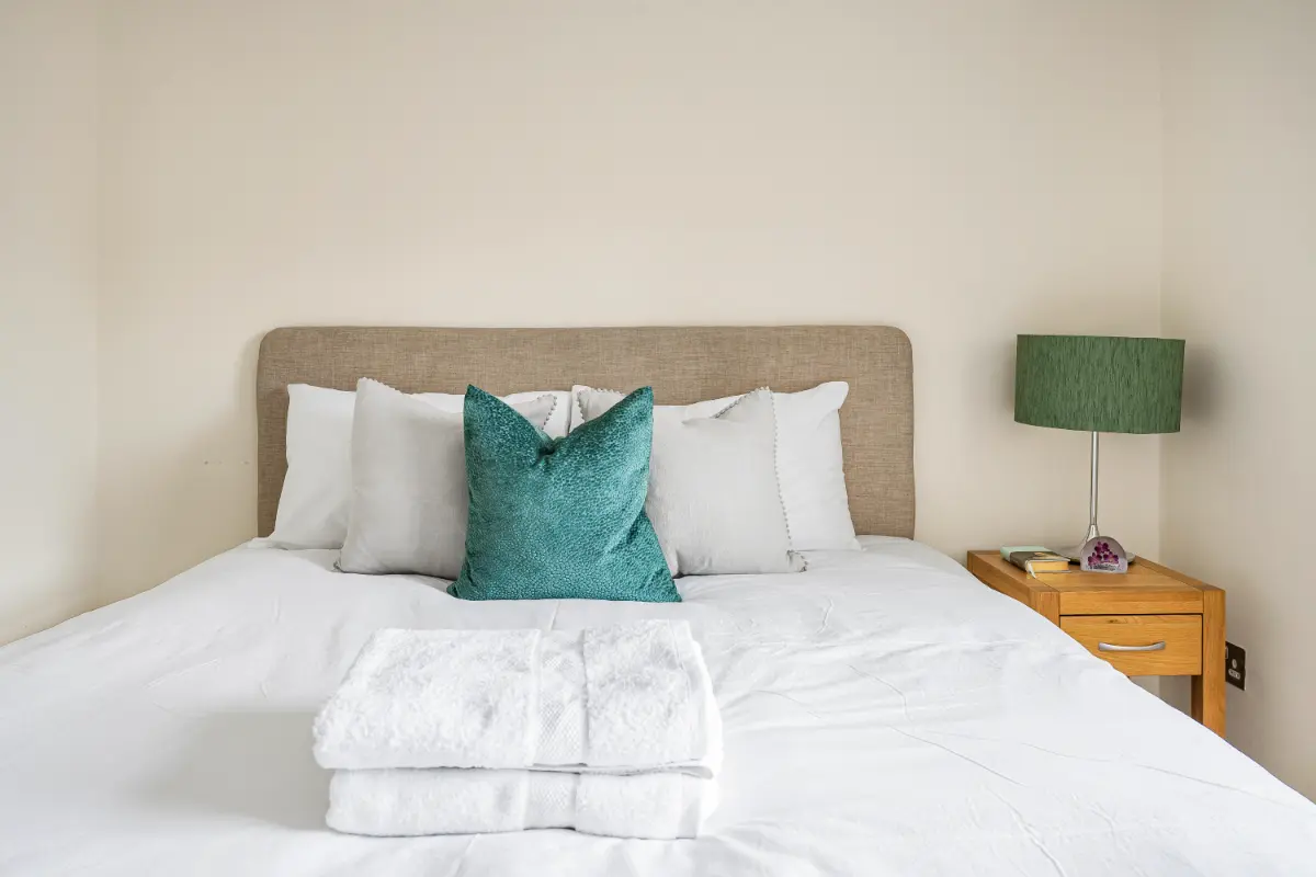 Close-up of the comfortable bed with fresh towels on top at Casa Cribs.