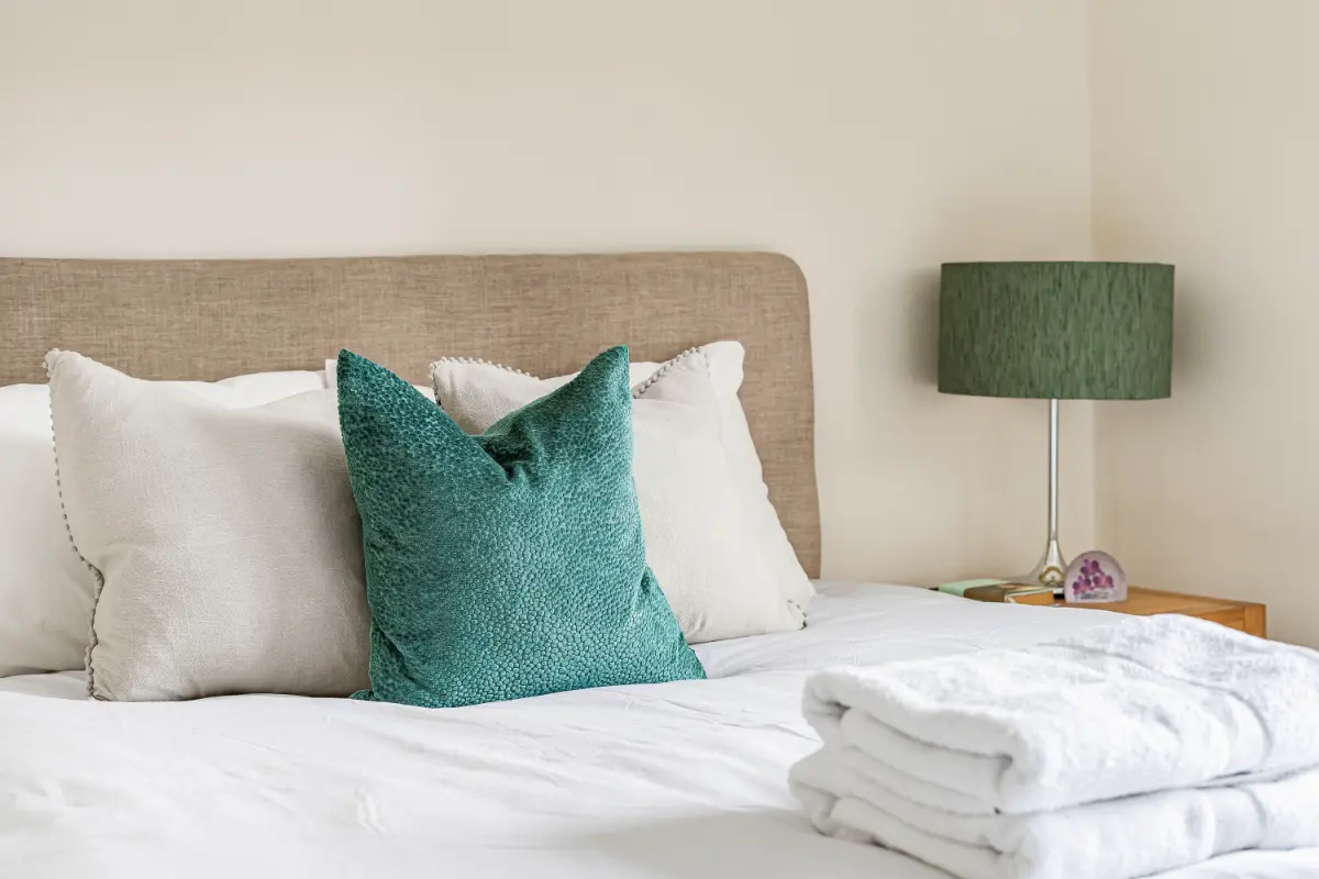 Comfortable bed at Casa Cribs with a green pillow and premium bedding.