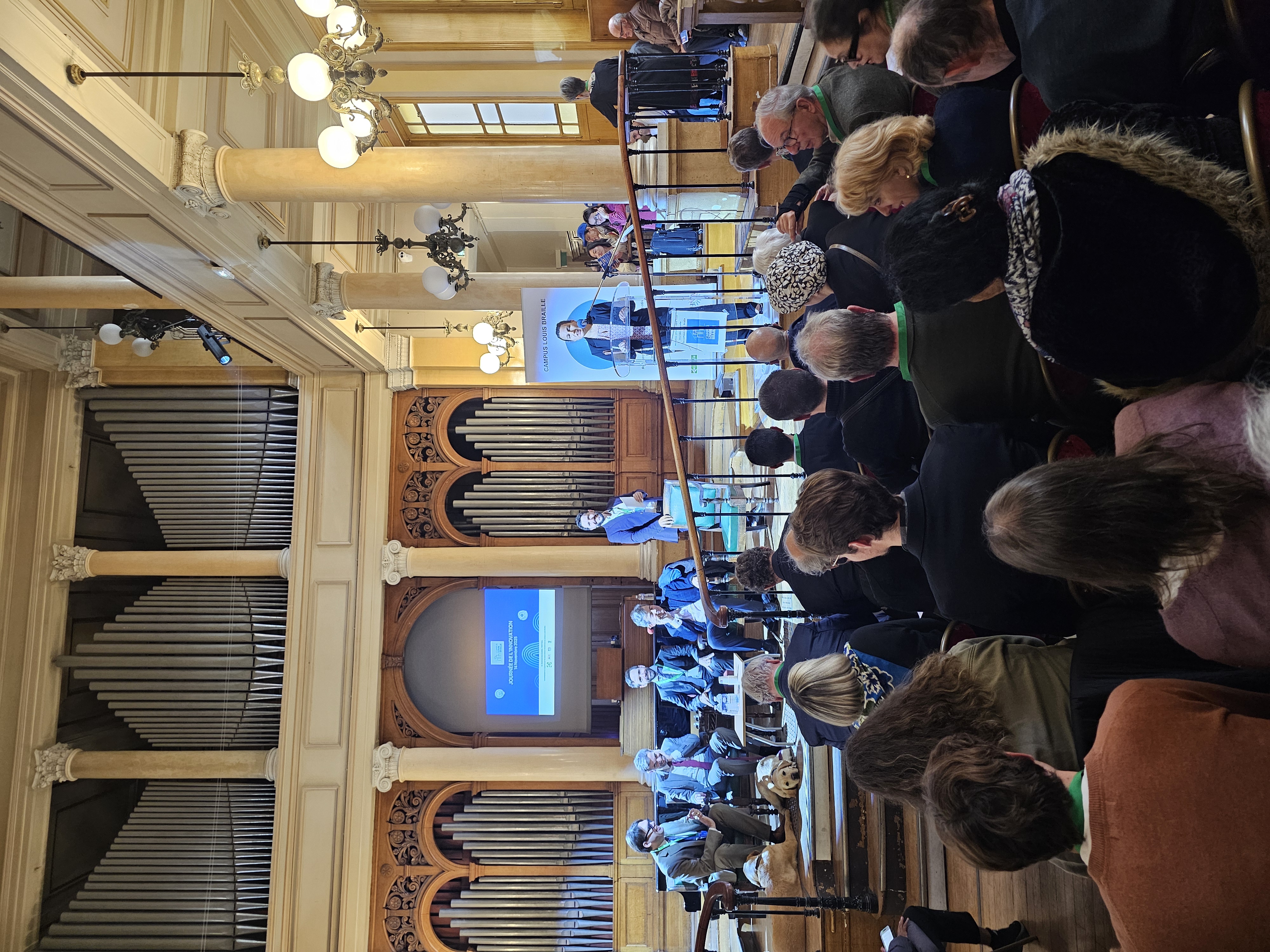 Image de la salle André Marchal pendant les présentations de la matinée, avec le public, les présentateurs, le piano et l’orgue