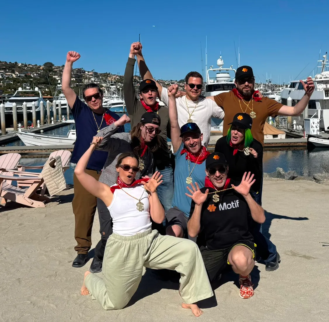A group of people posing for a picture on the beach.