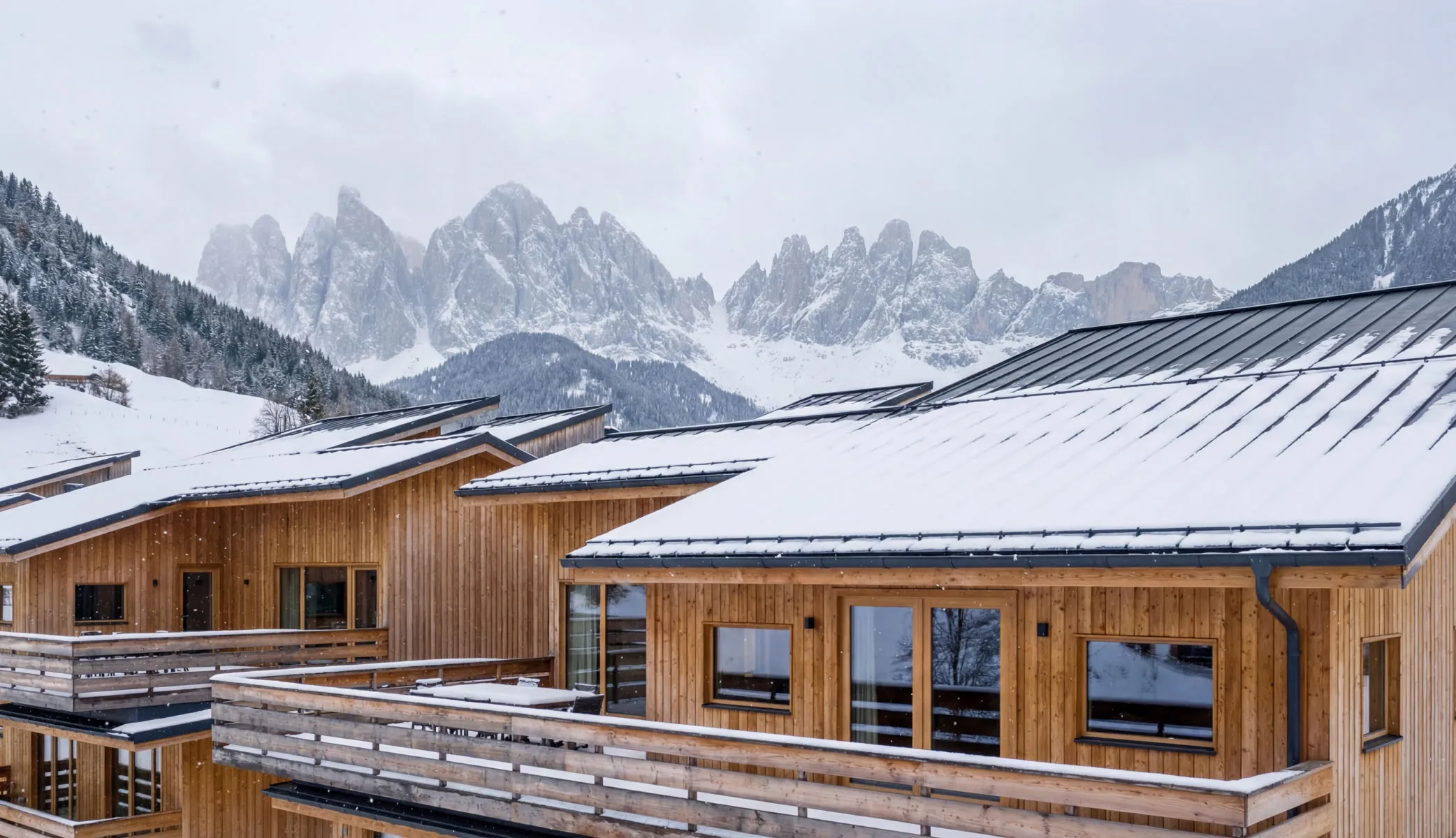A row of wooden buildings with snow on the tops.