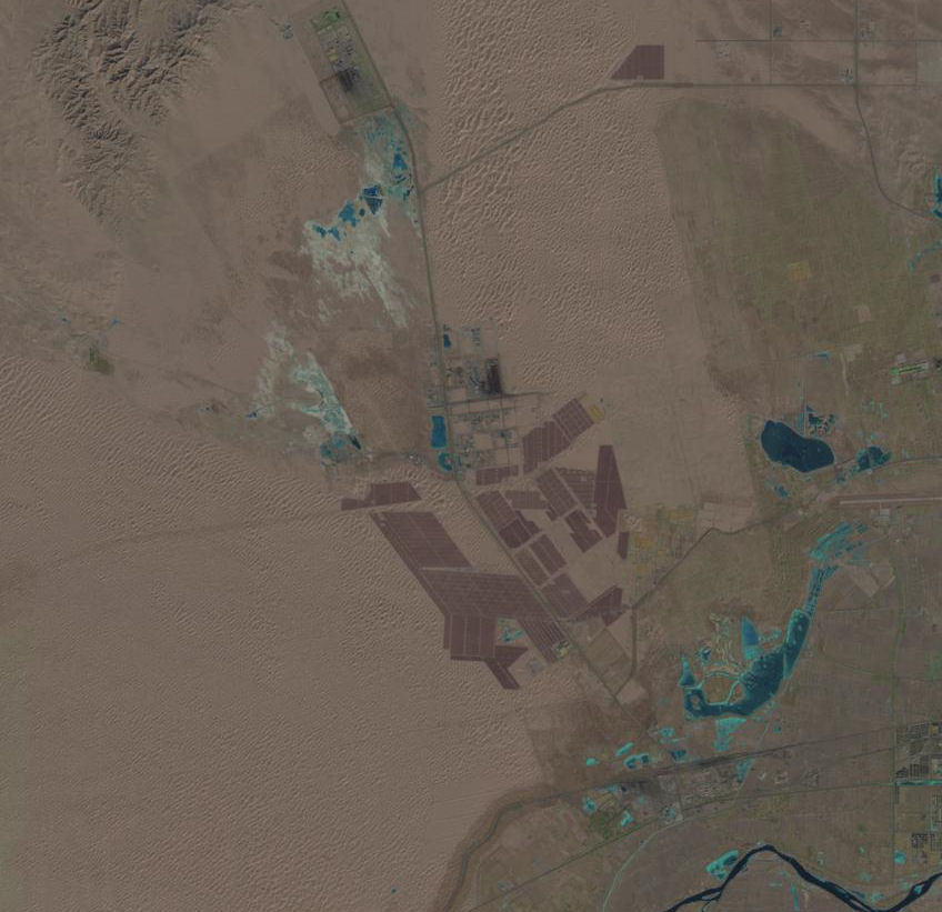 Satellite view of the Tengger Desert Solar Park in China, visible as dark geometric patches in the desert