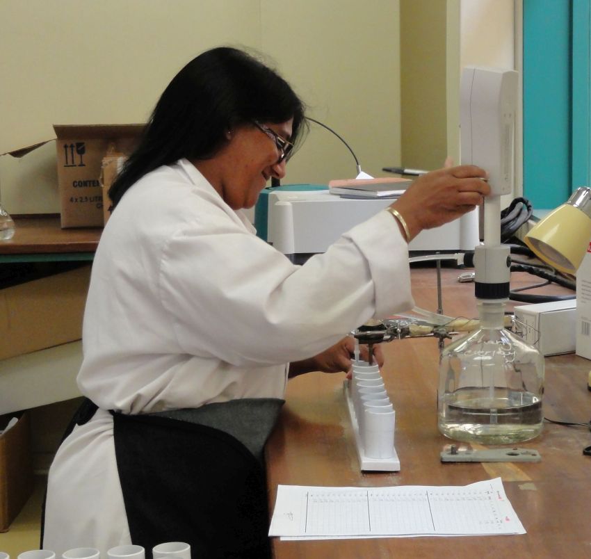 A researcher in a lab coat testing liquid samples in a laboratory