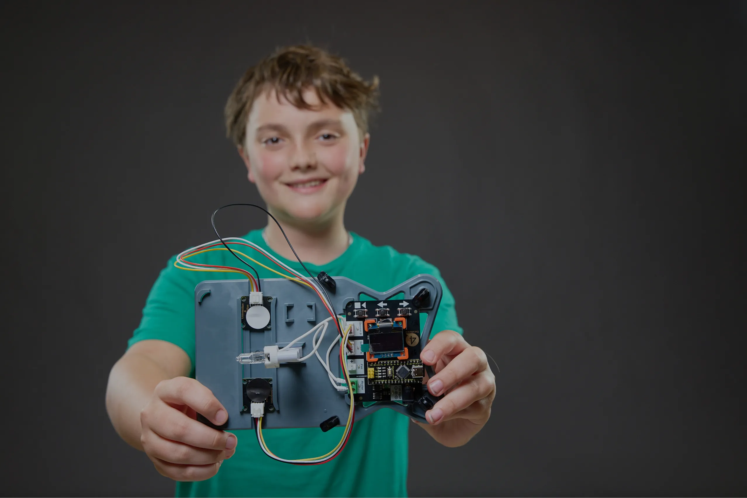 A student showing a robot component in their hands
