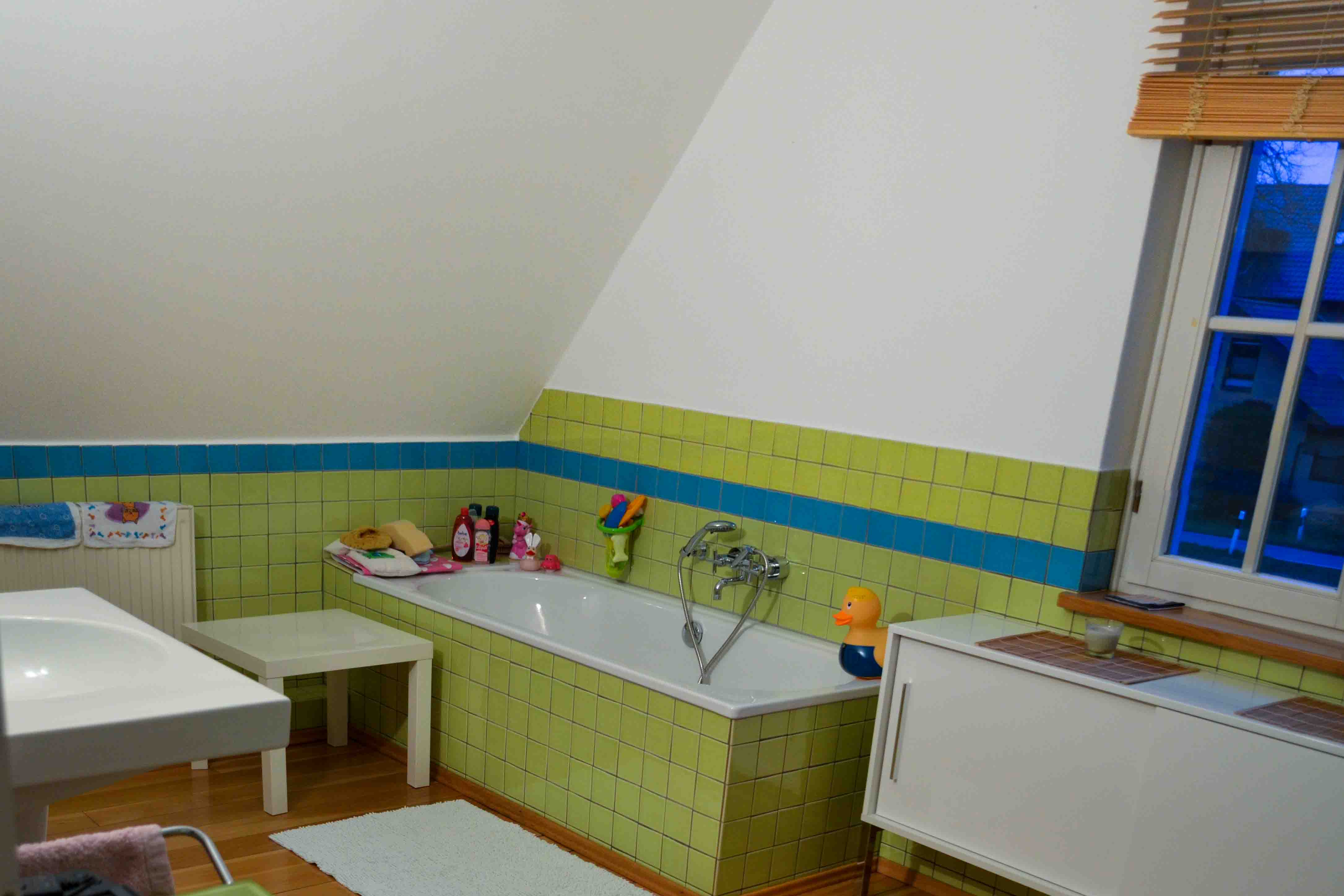 Badezimmer vor der Sanierung – altes Bad mit grünen Fliesen und Badewanne in einem Altbau