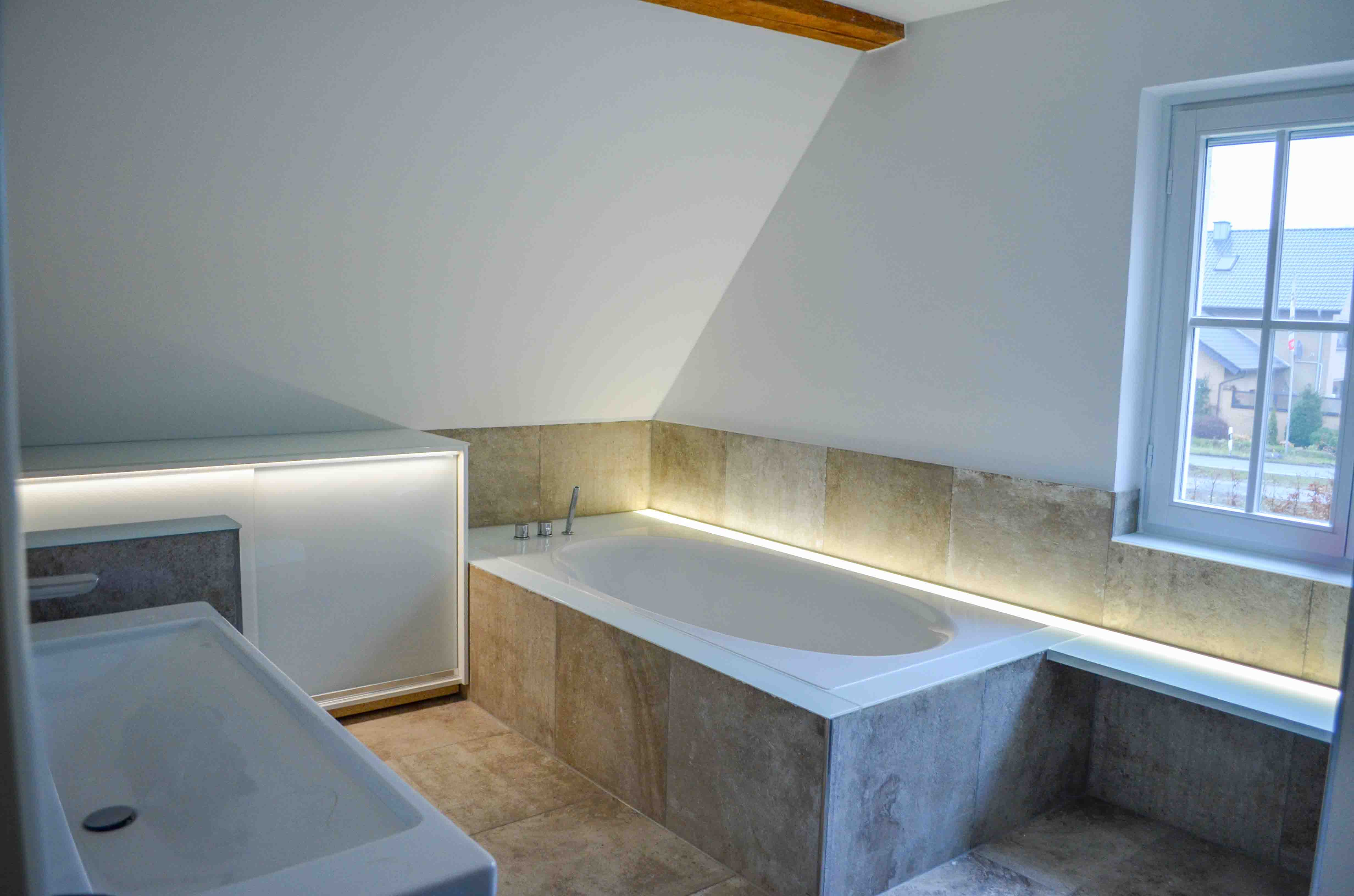 Modernisiertes Badezimmer nach der Sanierung durch Tassikas Haustechnik – neue Fliesen, Badewanne und indirekte Beleuchtung