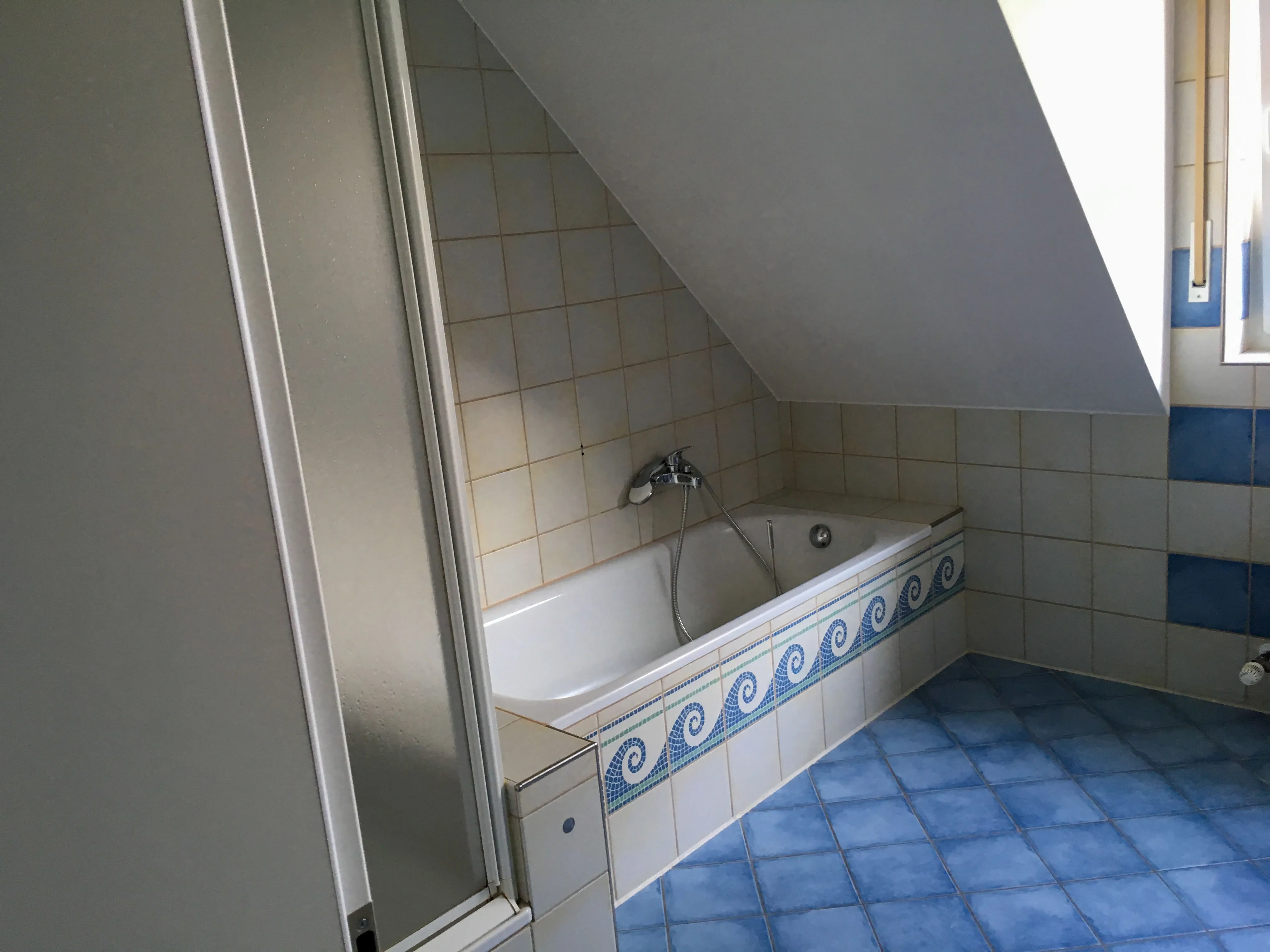 Ein altes Badezimmer mit blauen Fliesen