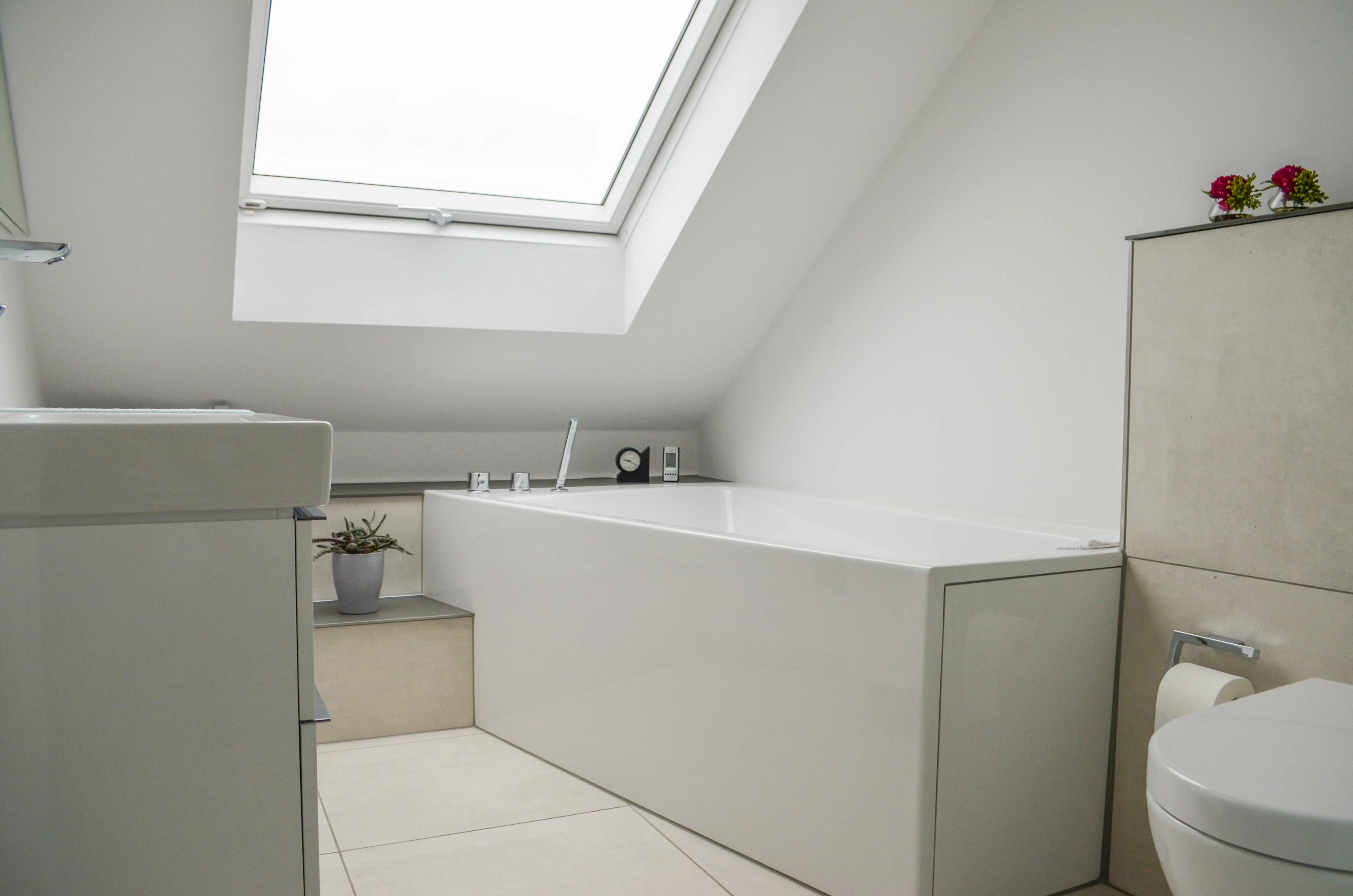 Ein helles, lichtdurchflutetes Bad mit Dachschräge.
