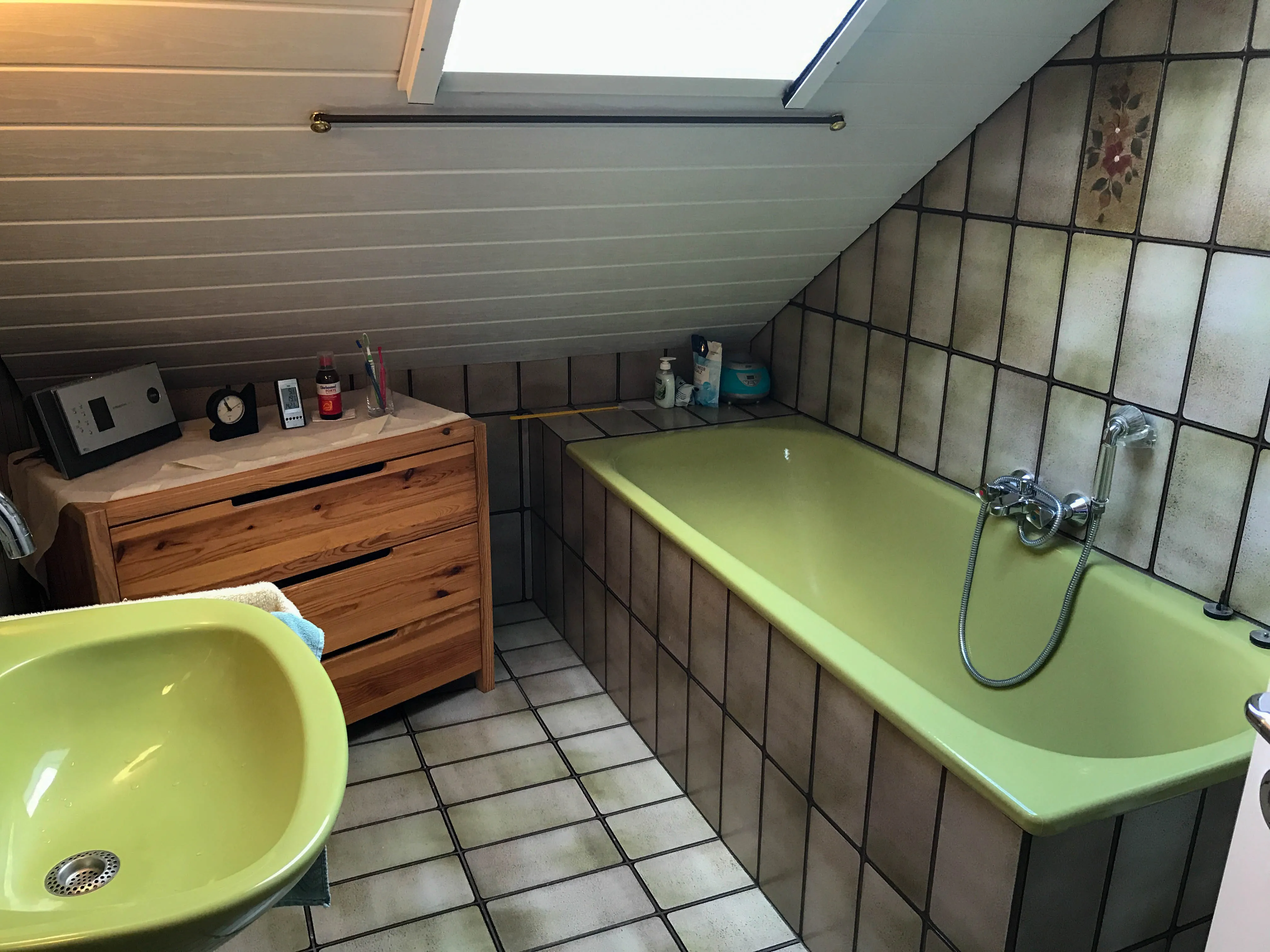 Ein altes Badezimmer im 70er Jahre Style mit grüner Keramik.