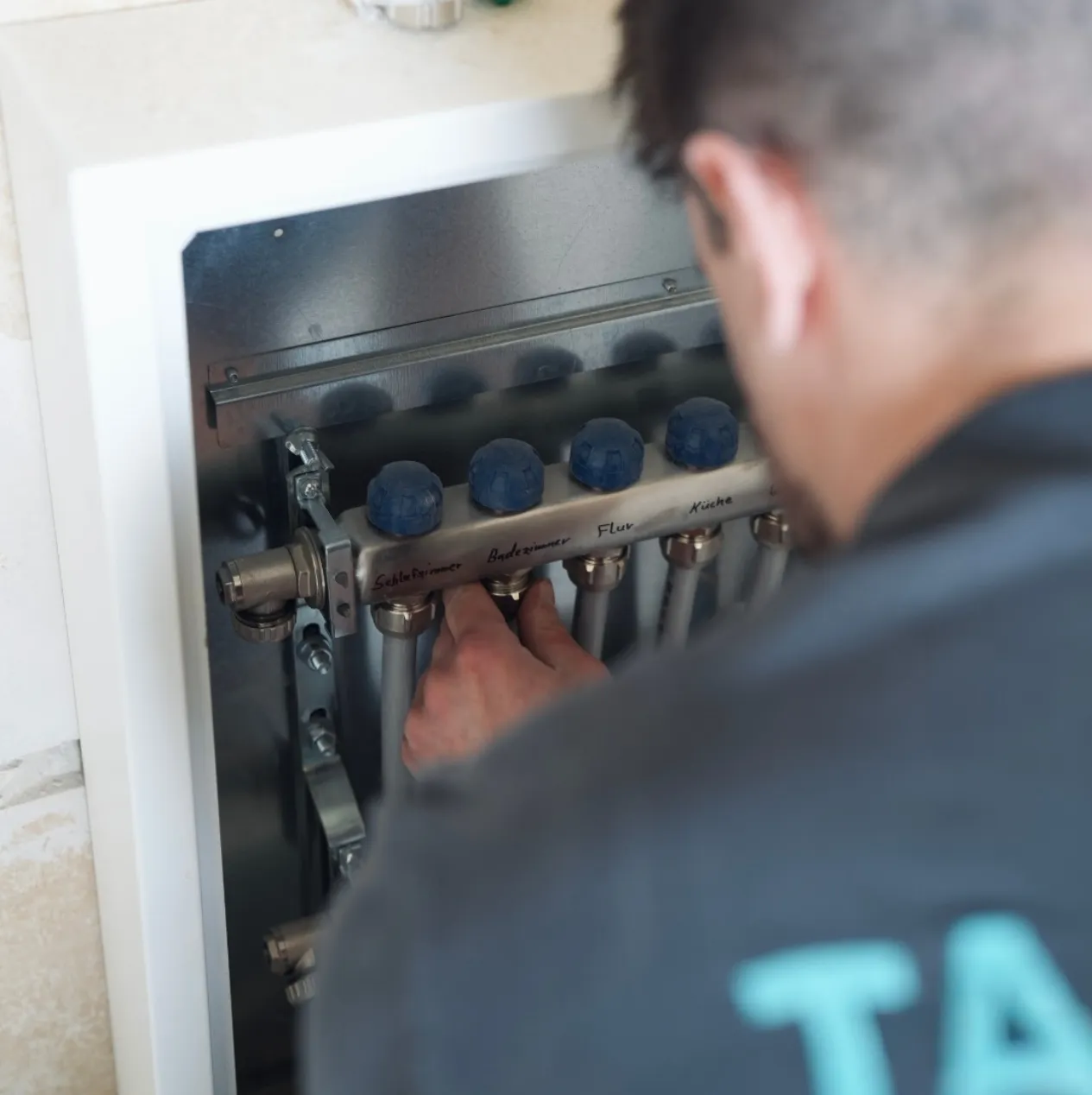 Ein Mitarbeiter stellt eine Fußbodenheizung ein.