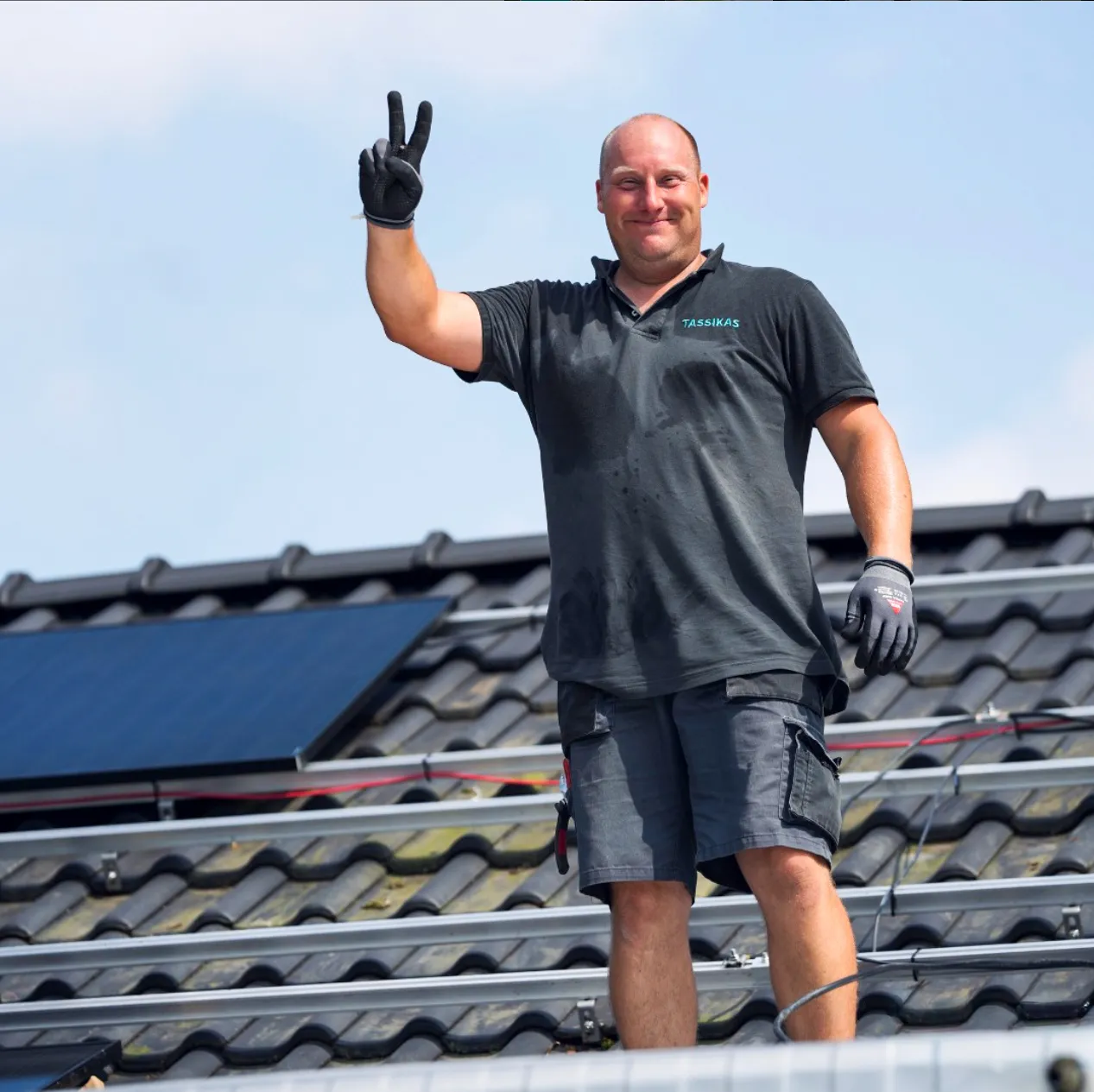 Ein Dachdecker winkt in die Kamera