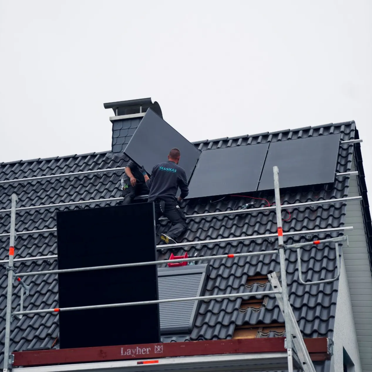 Zwei Monteure installieren auf dem Dach eine Photovoltaikanlage