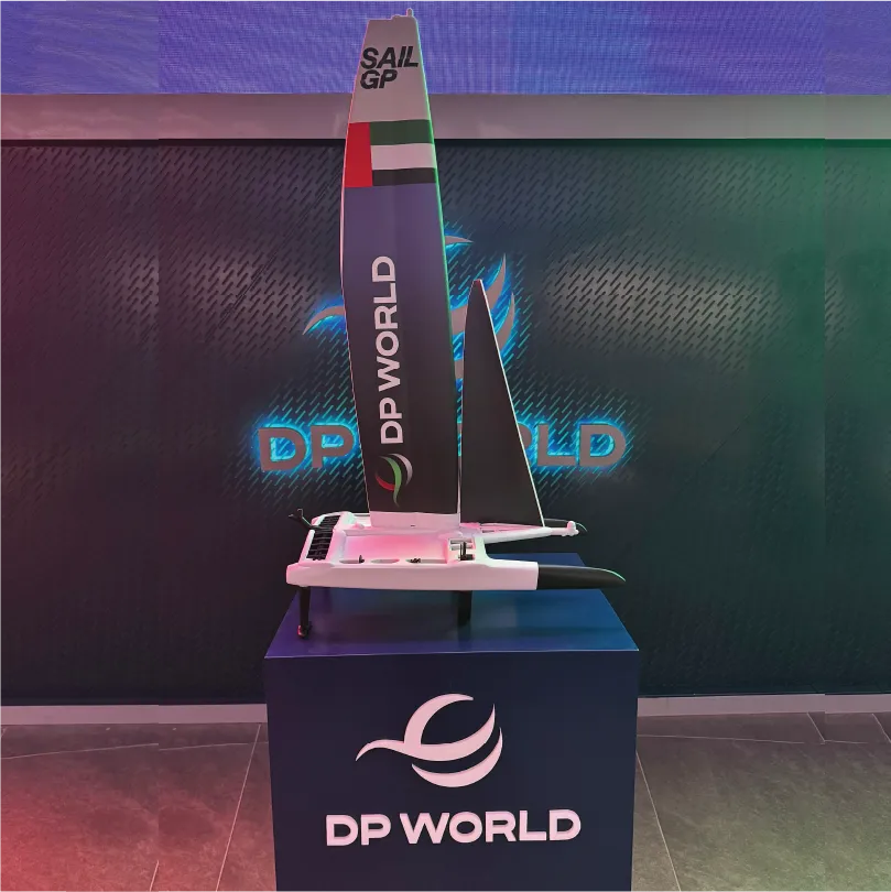 Model sailboat with SAIL GP and DP WORLD logos on a pedestal displaying the DP WORLD emblem.