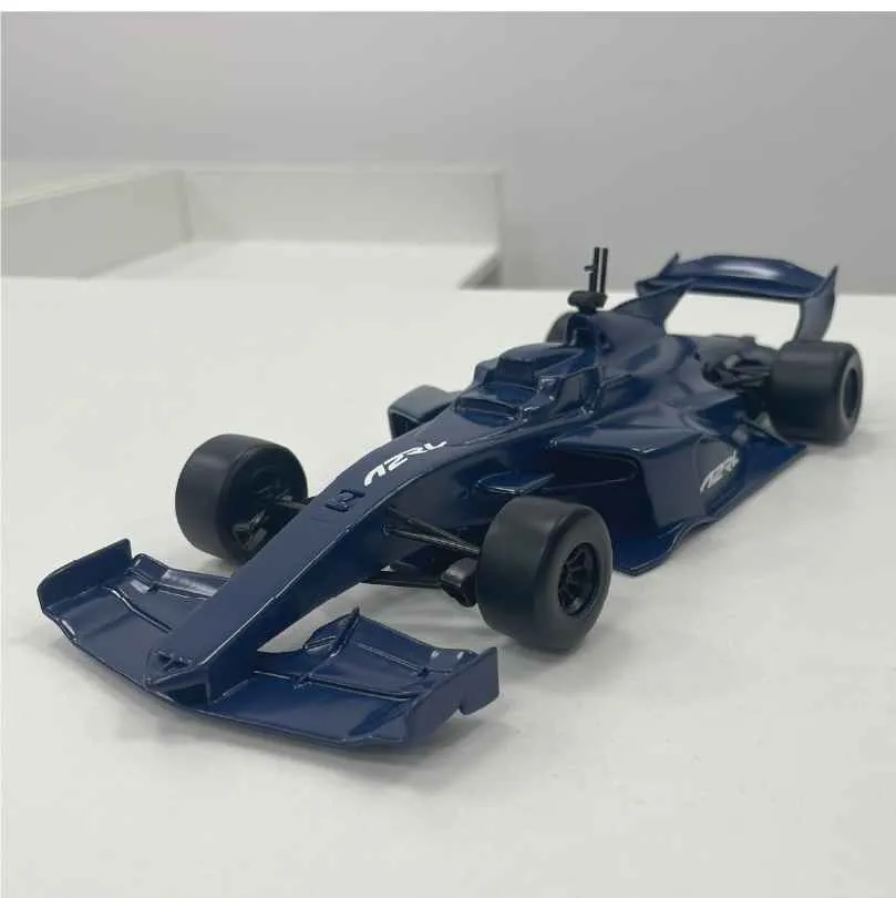 Dark blue model Formula 1 race car with wide front wing on a white surface.