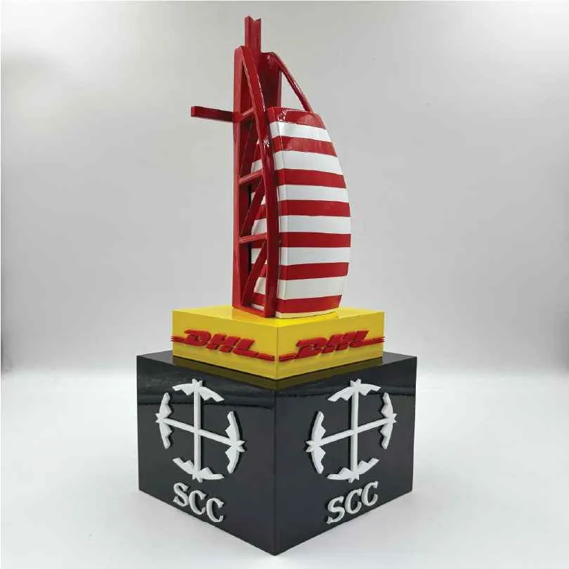 Model of a red and white striped sail tower on a yellow base with DHL and SCC logos.