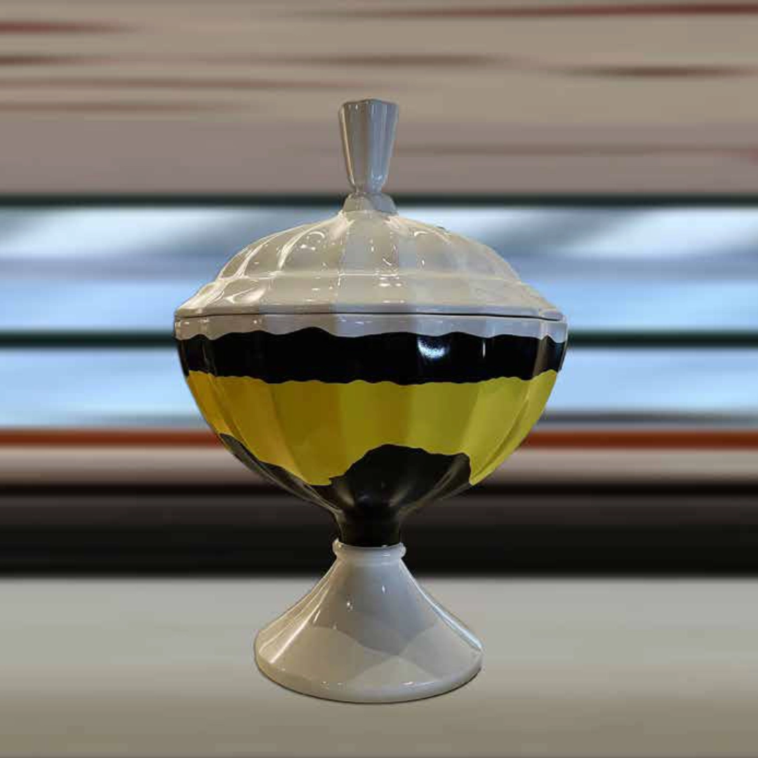 Decorative glass container with lid, white top and base, and a yellow and black middle band.